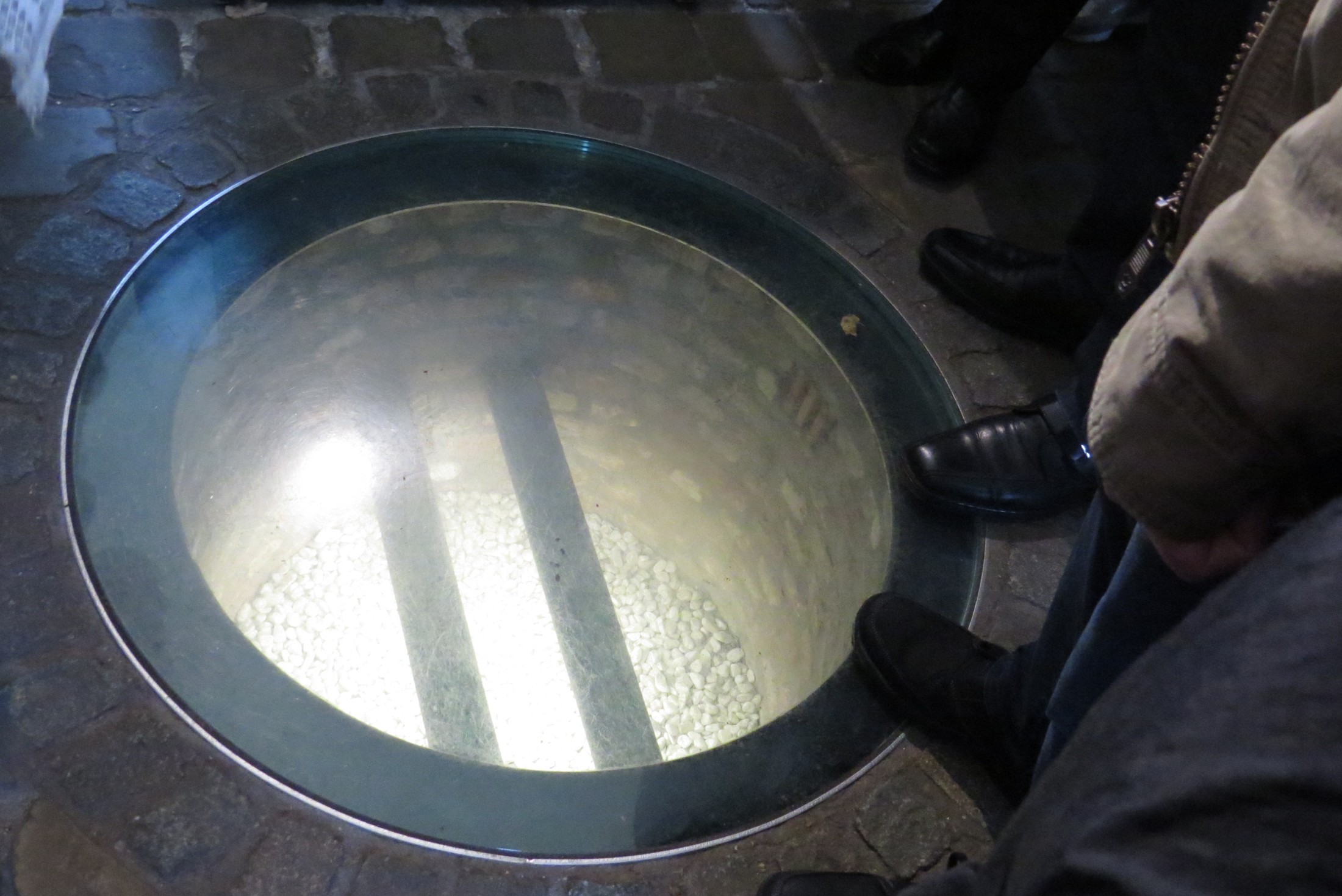 Een rond glazen kijkvenster in de vloer laat de bierleiding van De Halve Maan zien.