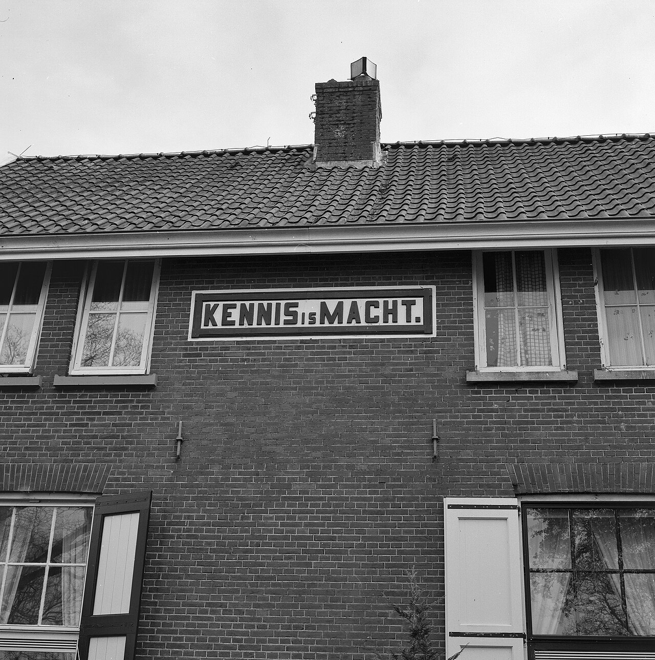 Een woning in Veenhuizen met een opvoedende spreuk op de gevel.