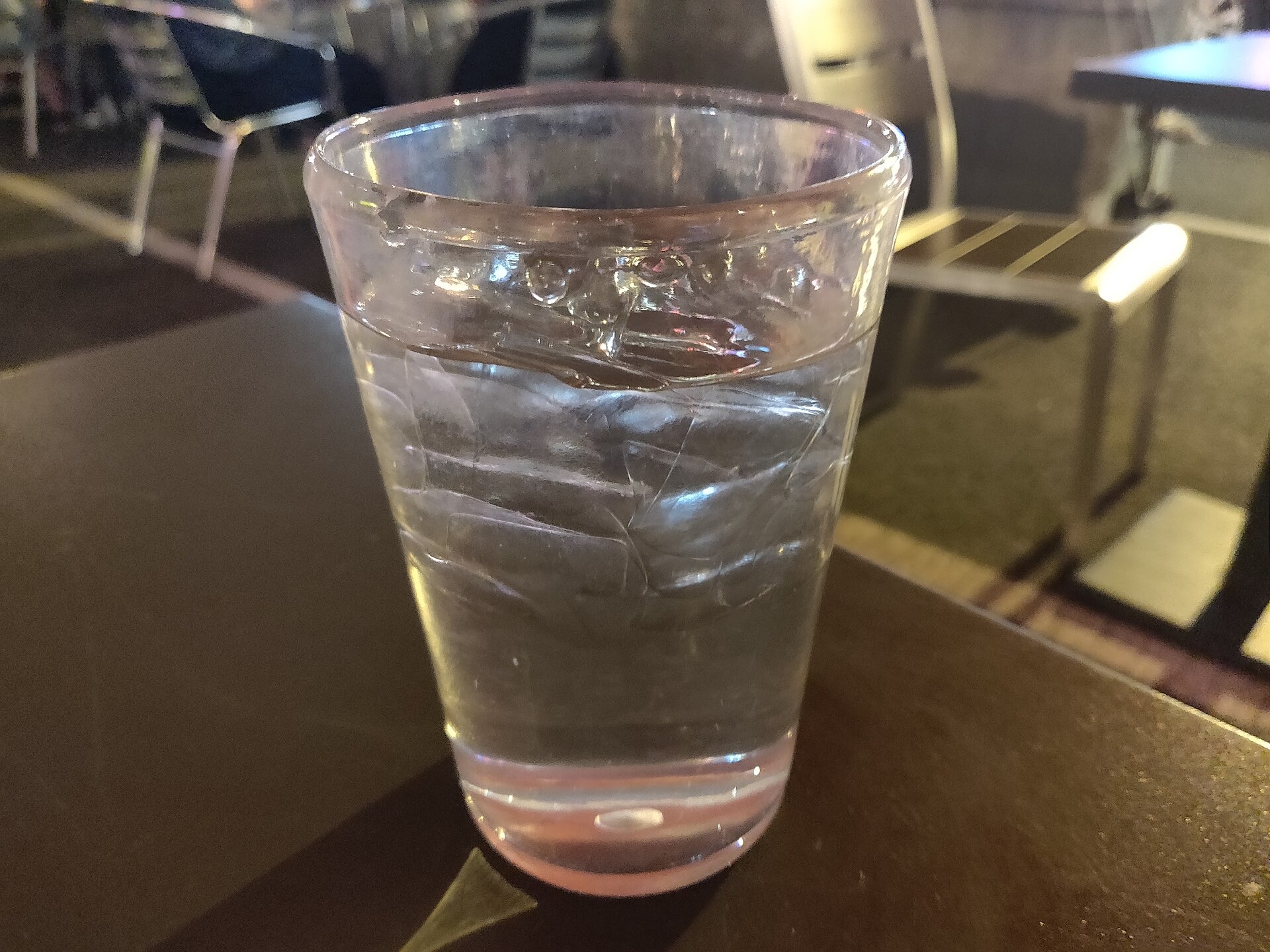 Glas water met ijs op een tafel.