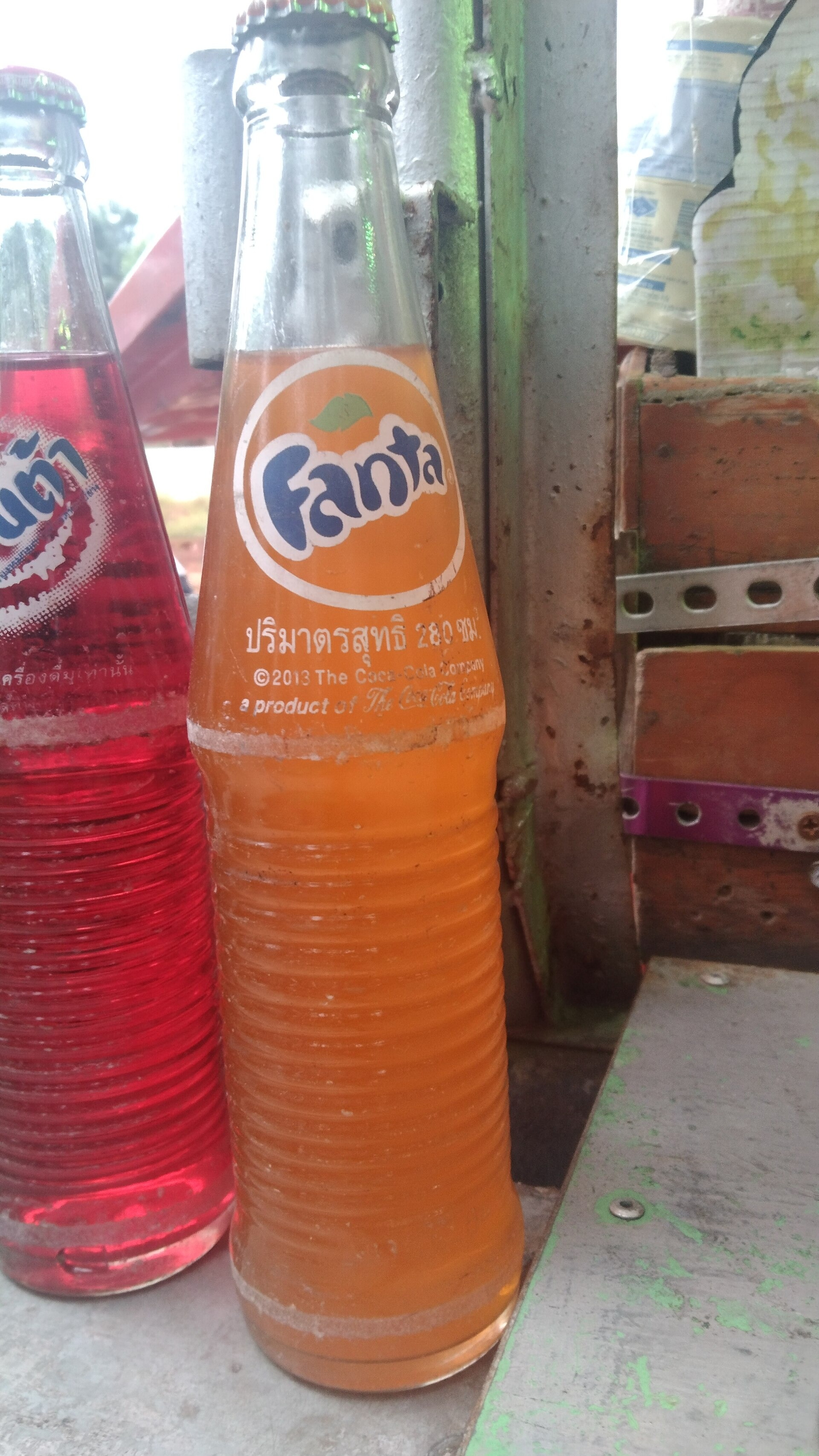 Glazen fles Fanta Orange met oranje frisdrank.