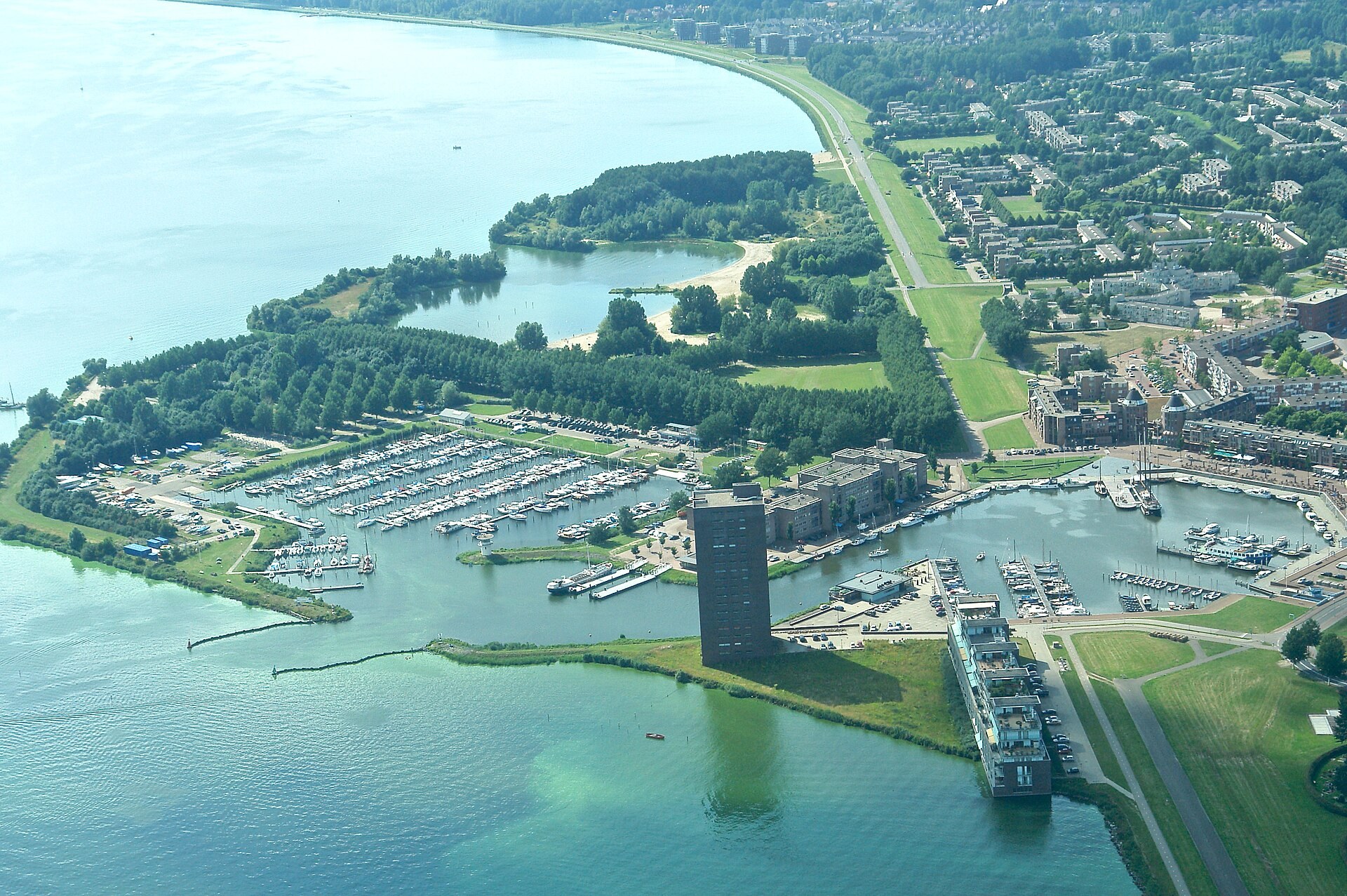 Luchtfoto van de haven en bebouwing van Almere Haven; illustratief beeld van de latere stad, niet van de eerste sleuteluitreiking.
