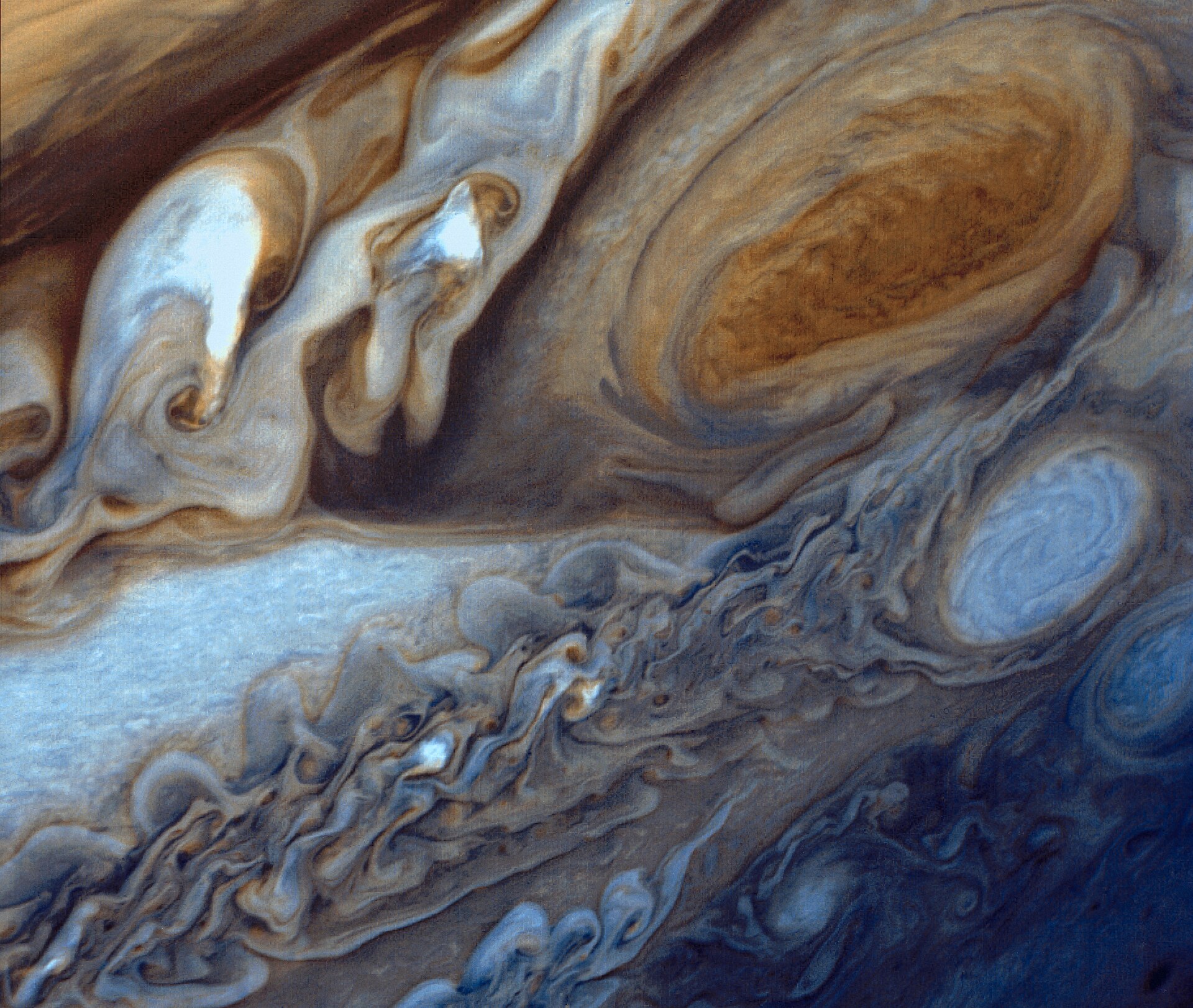 Kleurrijke wolkenbanden rond de grote ovale Rode Vlek op Jupiter.