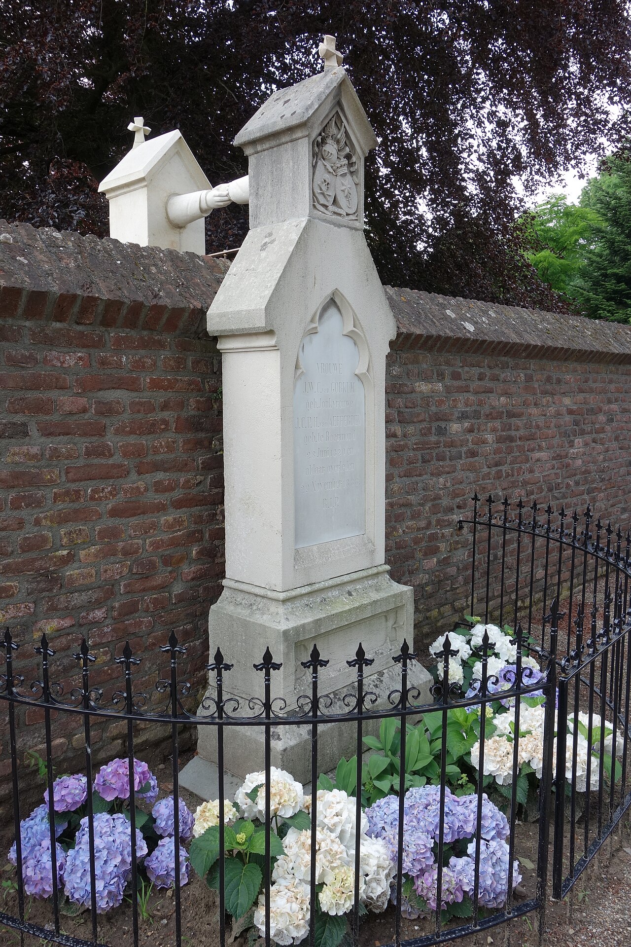 Een zijde van het Graf met de handjes in Roermond, met de stenen verbinding boven de kerkhofmuur.