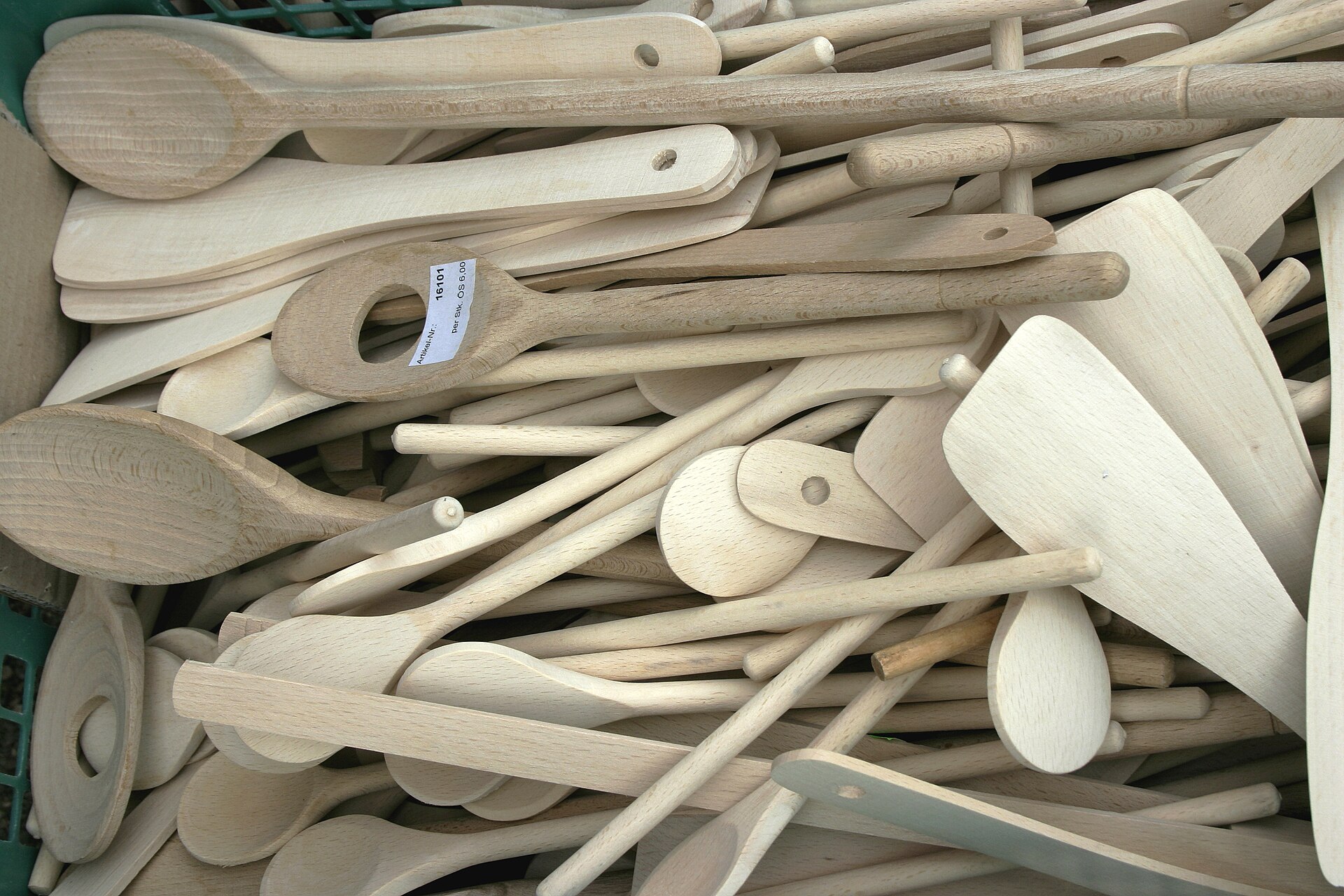 Verschillende lichte houten roerlepels en spatels liggen door elkaar.