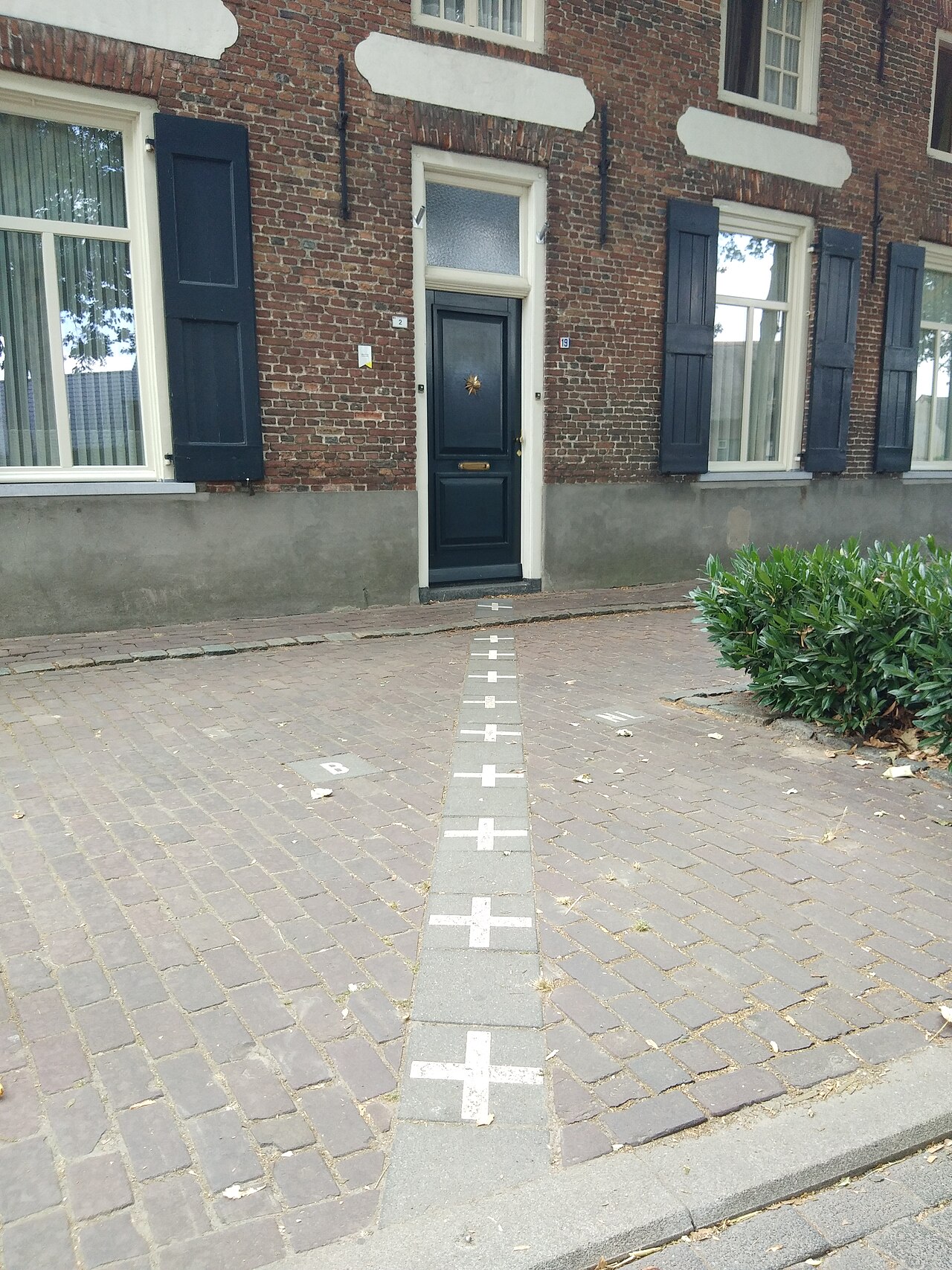 De grens loopt over de stoep naar een huis in Baarle.