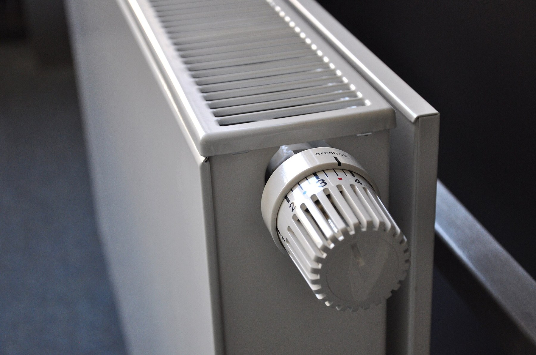 Witte radiator met een thermostaatknop aan de zijkant.