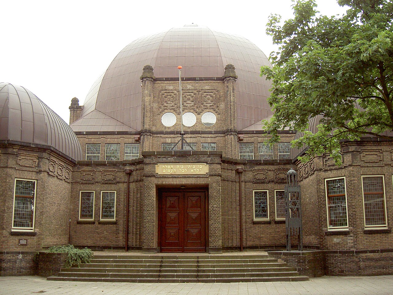 De ingang en bakstenen gevel van de synagoge in Enschede.
