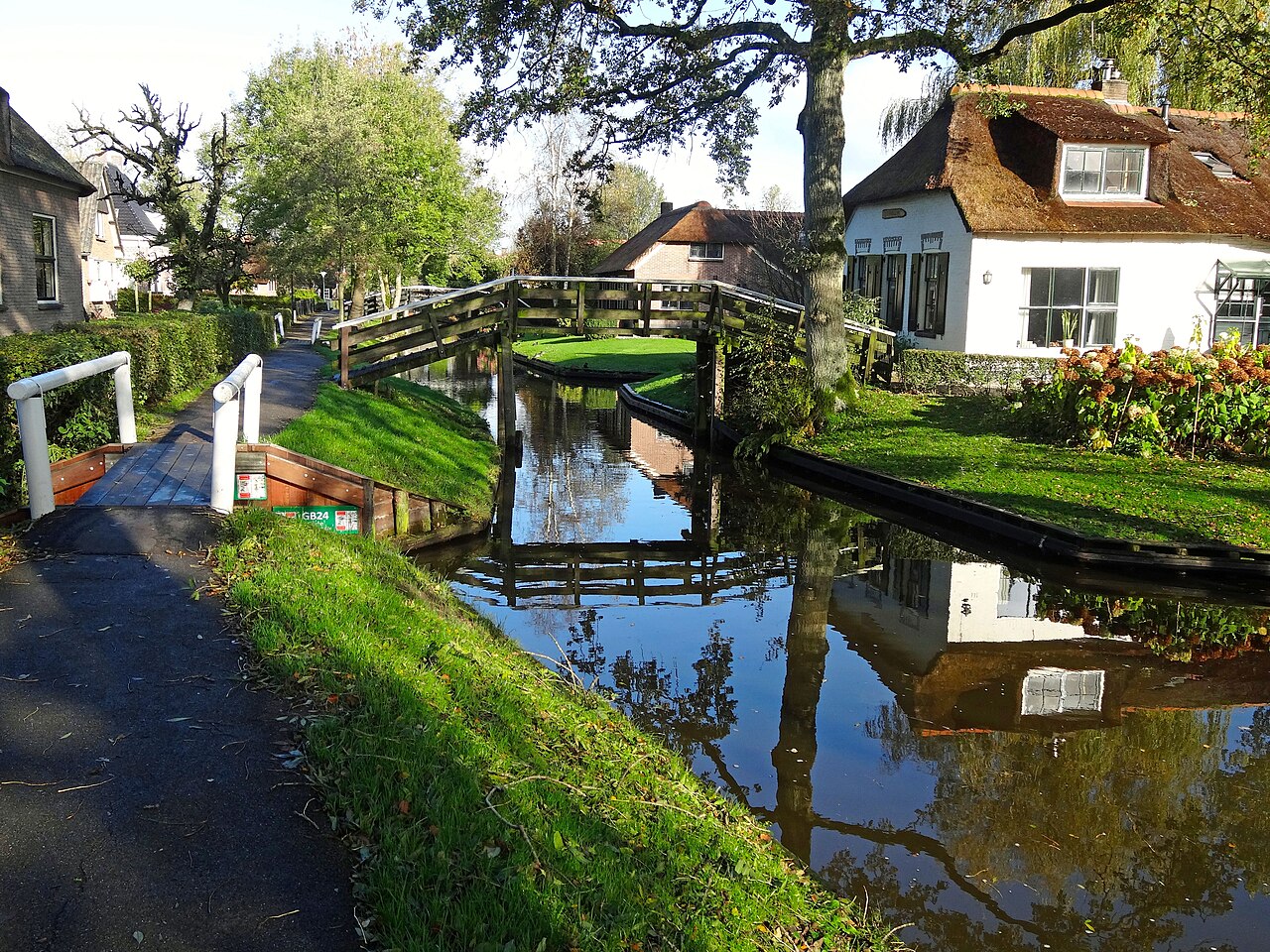 Een gracht, bruggetje en huizen langs het Binnenpad in Giethoorn.