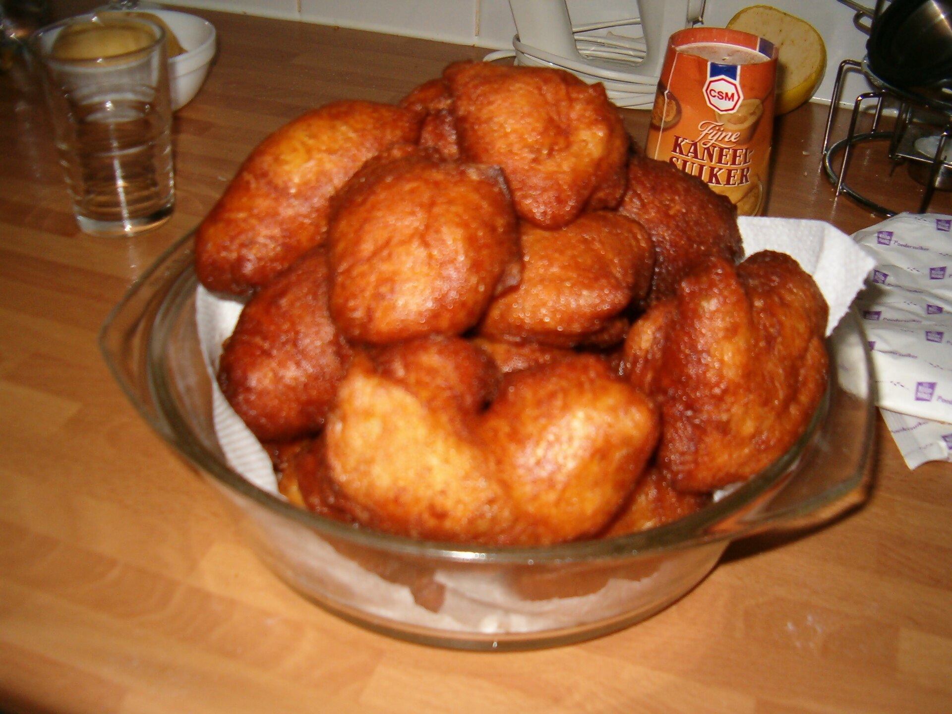 Een schaal met oliebollen op een tafel.