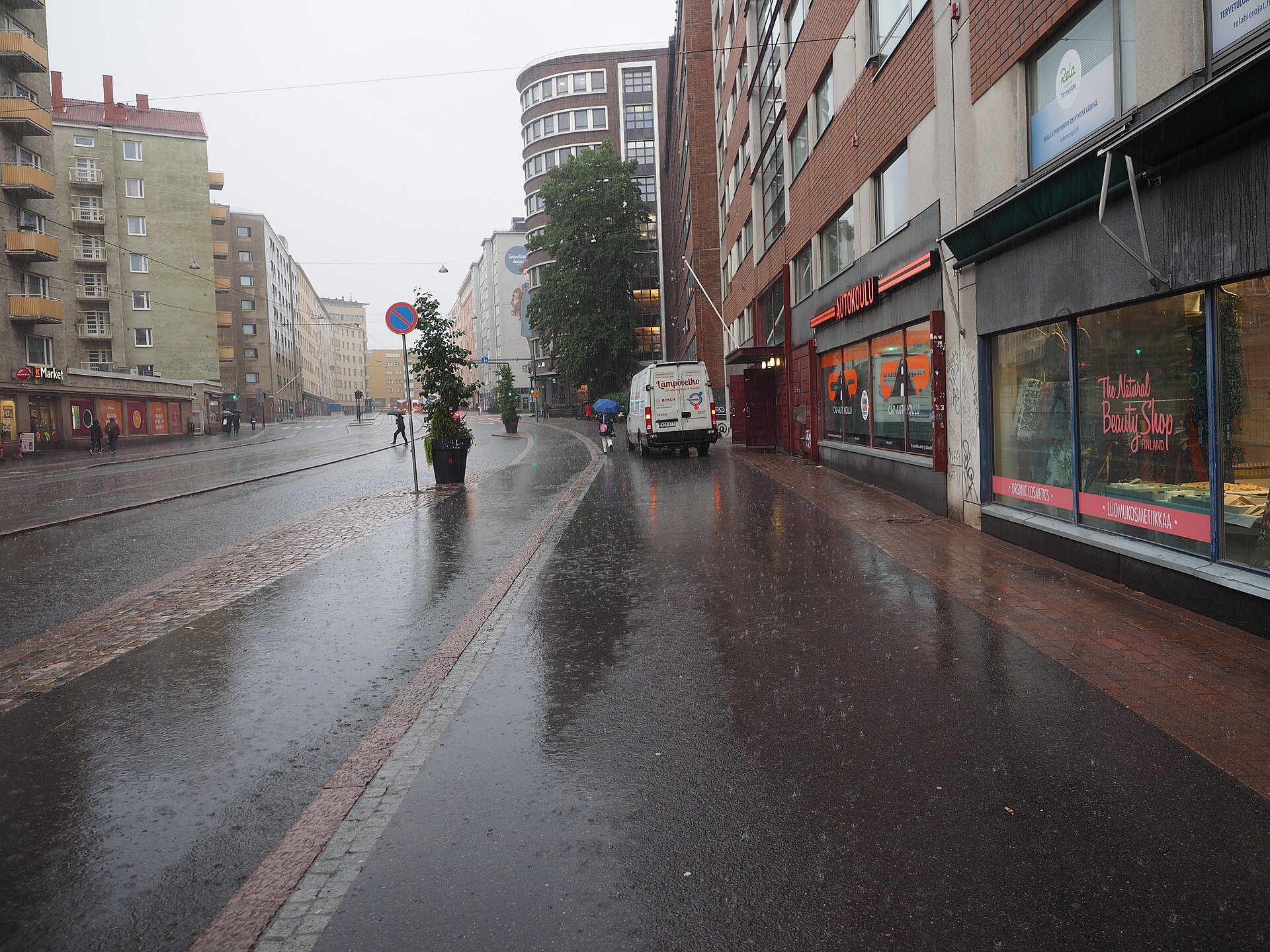 Een natte straat in Helsinki tijdens een regenbui.
