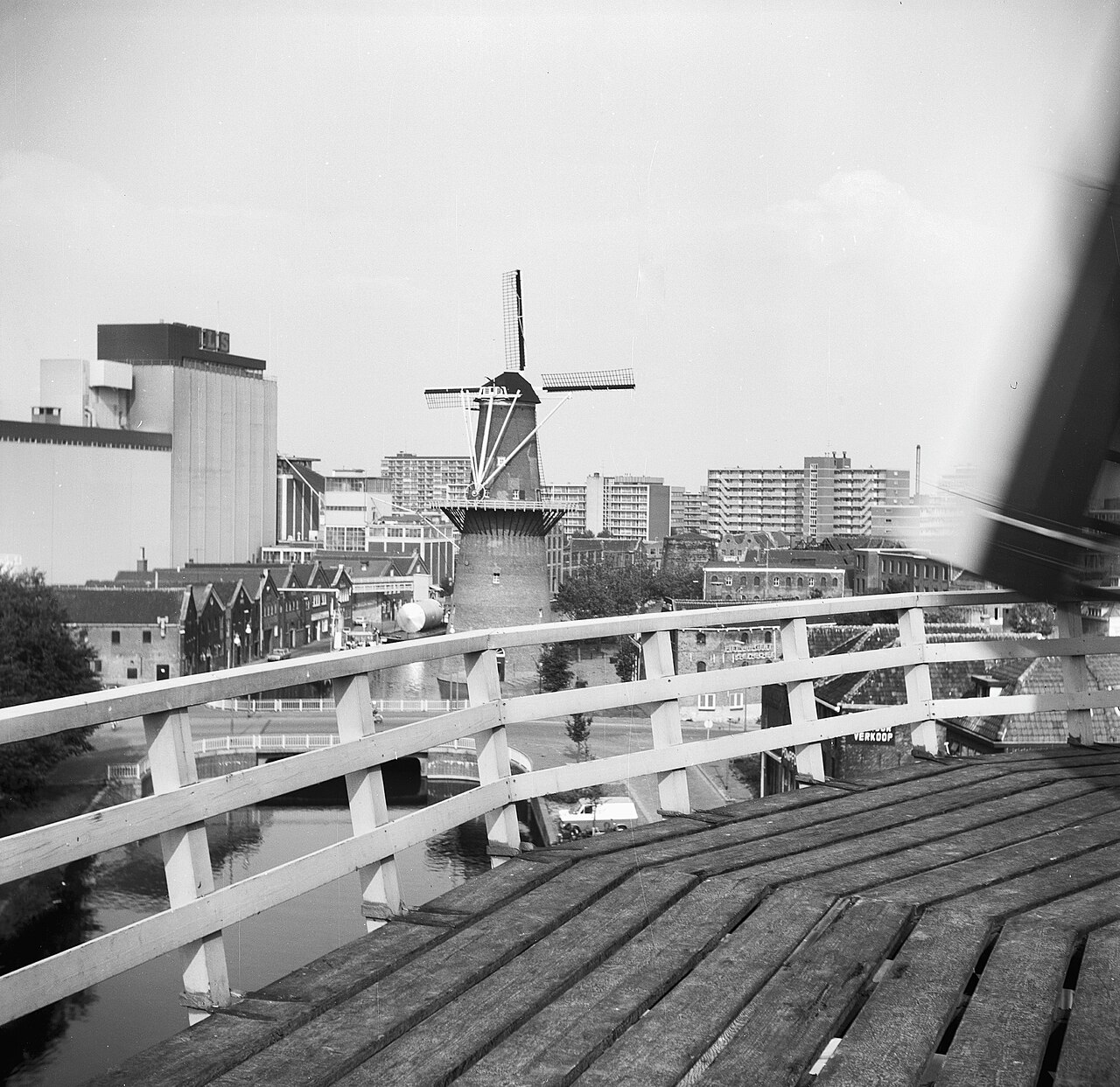 Zwart-witfoto van molen De Noord in Schiedam, gezien vanaf de houten stelling van een andere molen.