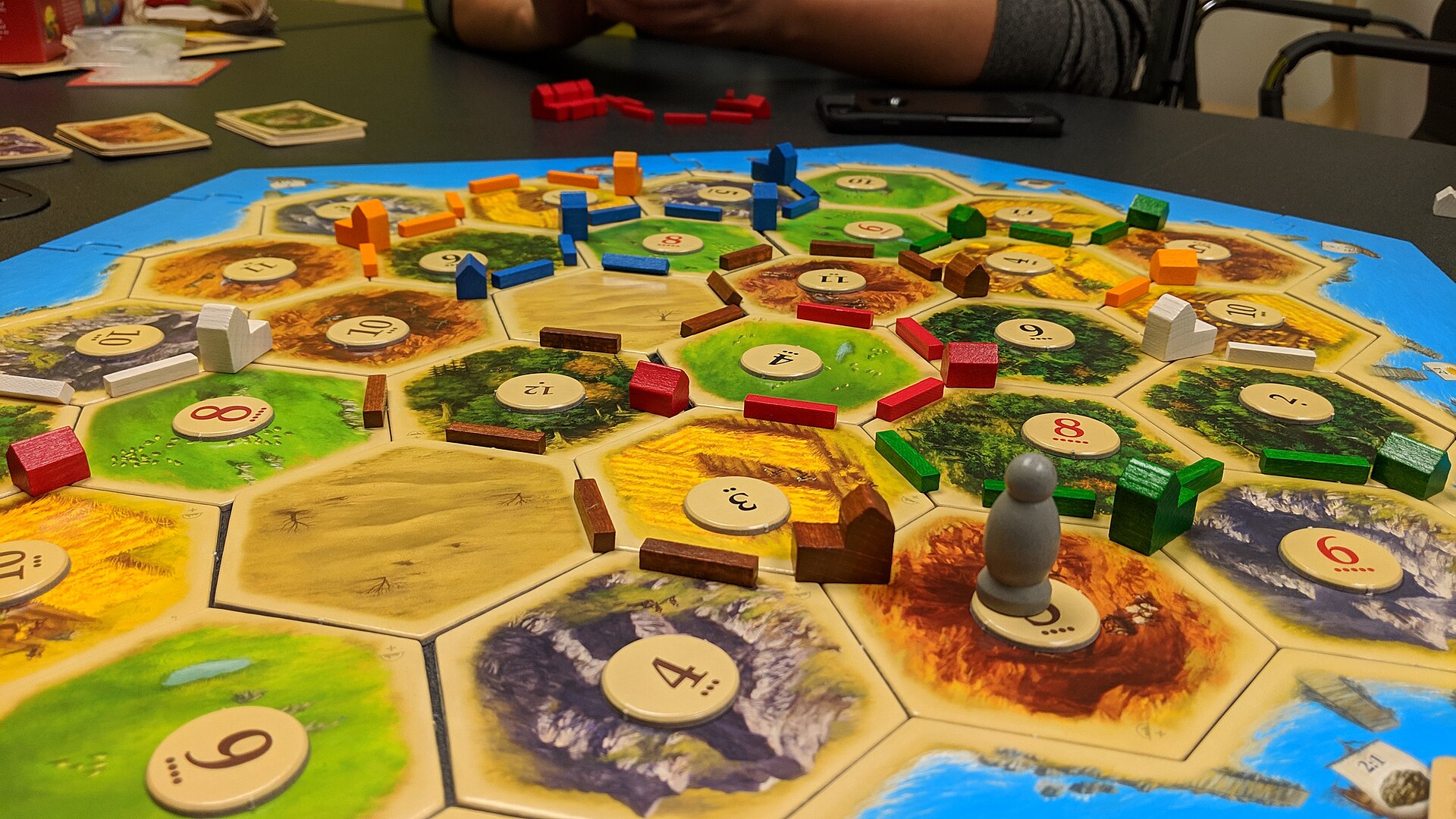 Een opgebouwd CATAN-speelbord met tegels, dorpen, wegen en dobbelstenen.