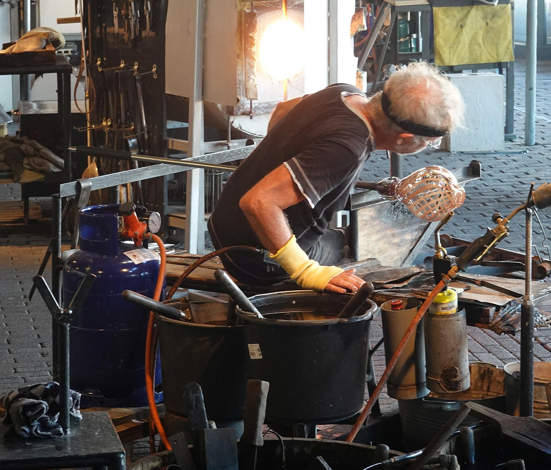 Een glasblazer aan het werk in de Glasblazerij van het Nationaal Glasmuseum in Leerdam.