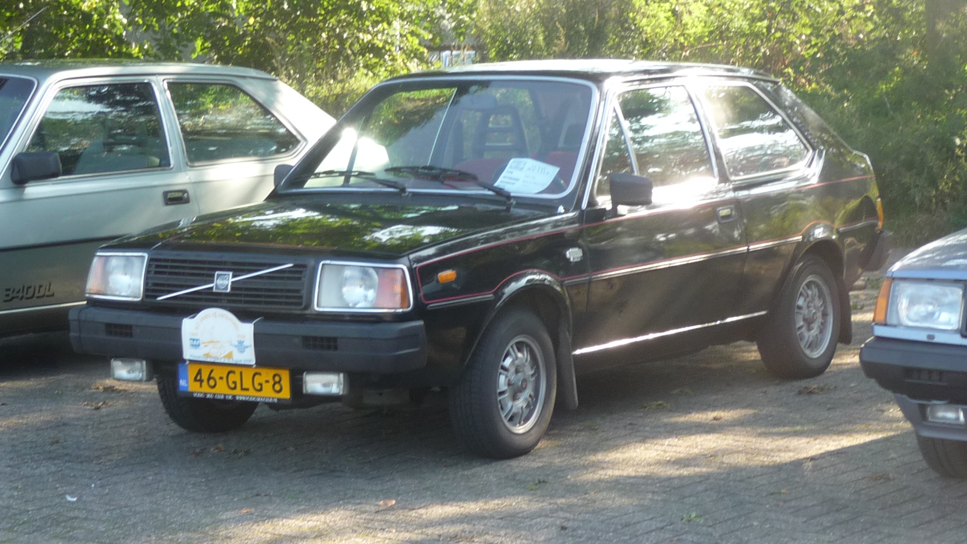 Een zwarte driedeurs Volvo 343 met rode bies op een Nederlandse klassiekerbijeenkomst.