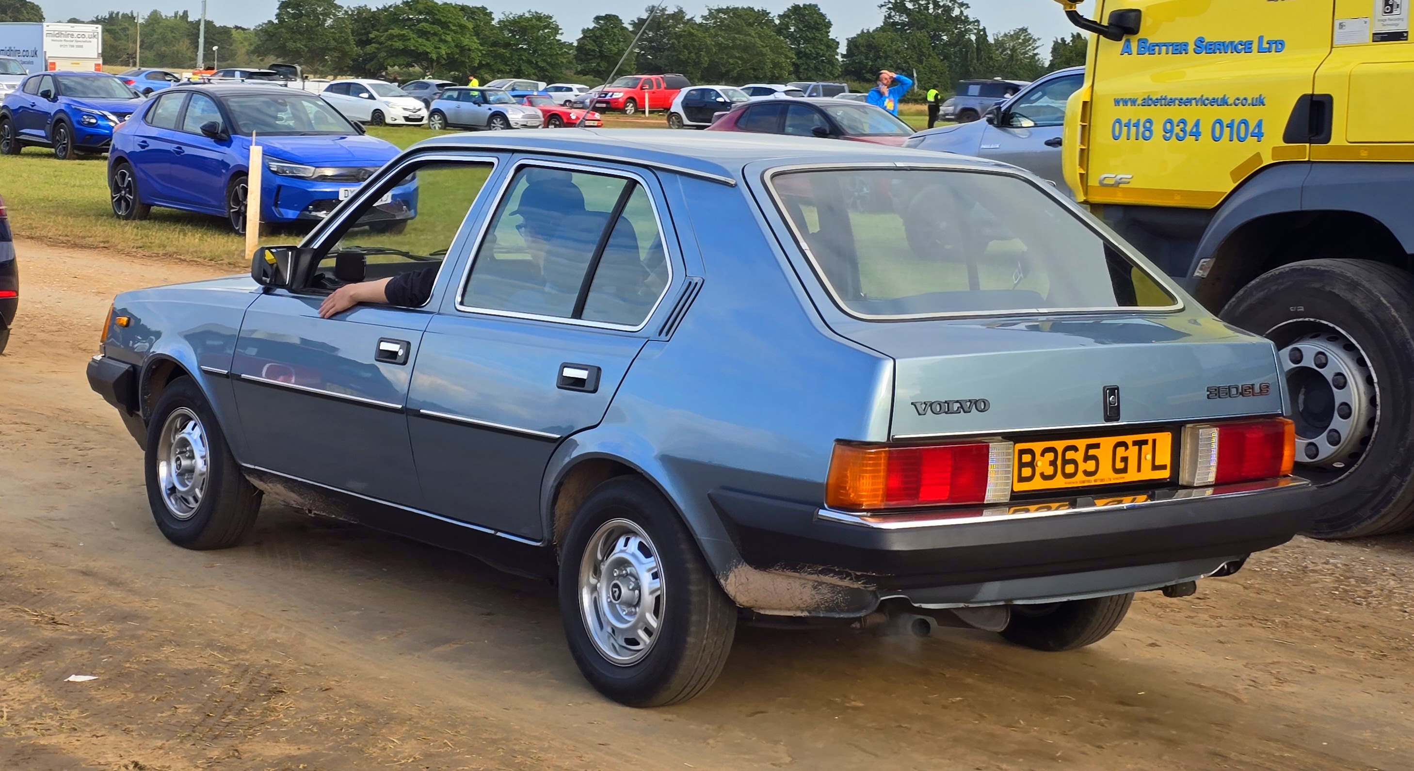 Een blauwe Volvo 360 GLS met aparte kofferklep en zichtbaar typeplaatje, schuin van achteren gefotografeerd.